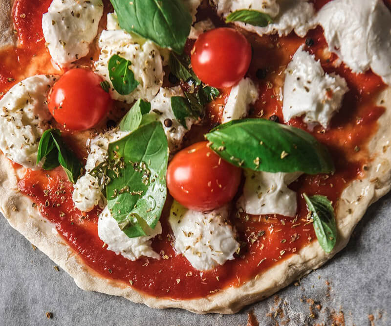 Pizza à la tomate garnie de mozzarella et de basilic